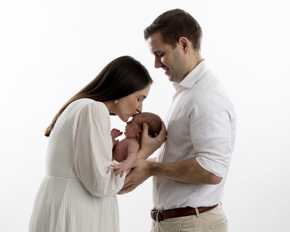 newborn photographer sudbury ma studio parents kissing newborn