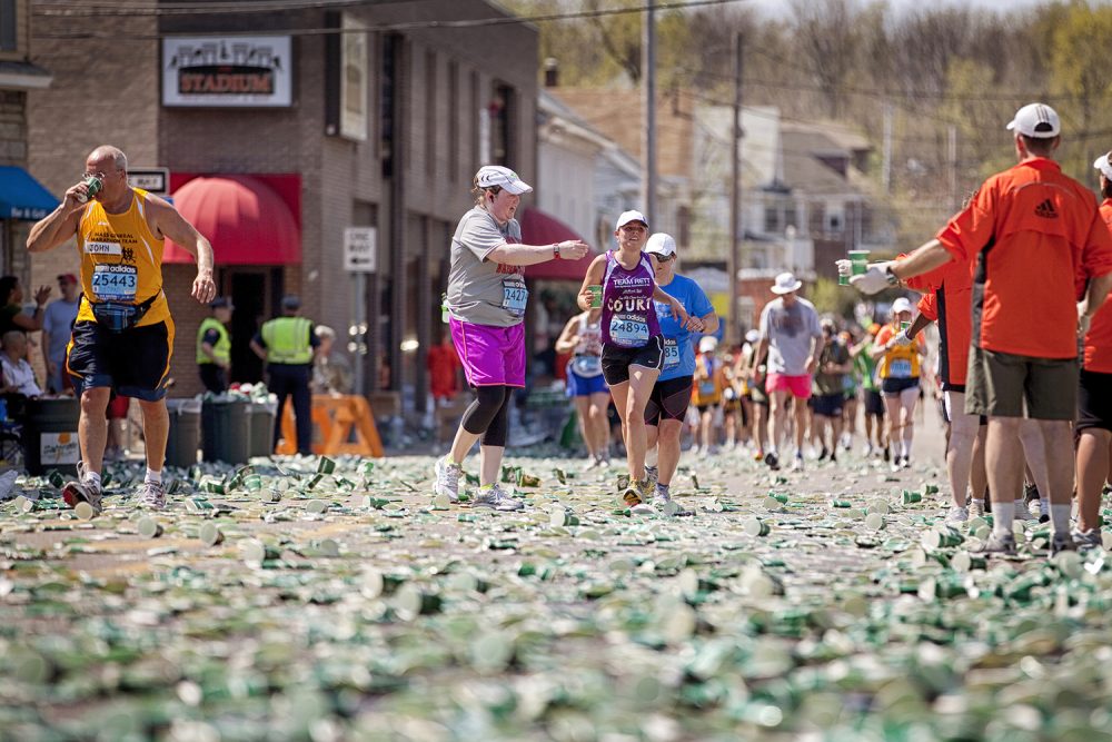 02 marathon volunteers handing water runners